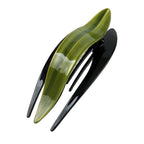 Detail close-up of a curved acetate hairpin in green and black, highlighting its sleek design.