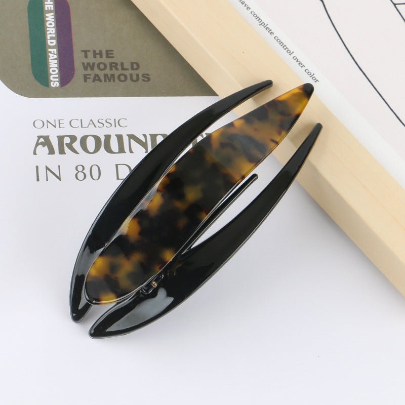 Detail close-up of a multi-colored acetate hairpin, showcasing its vibrant colors and unique style.