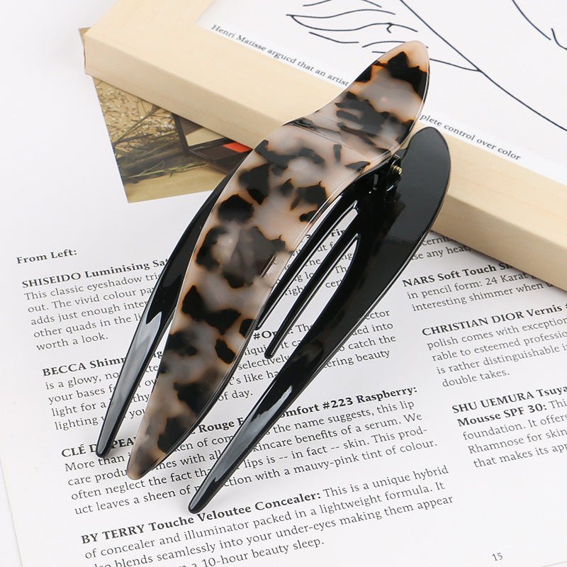 Detail close-up of leopard print acetate hairpin, emphasizing its stylish pattern and glossy finish.