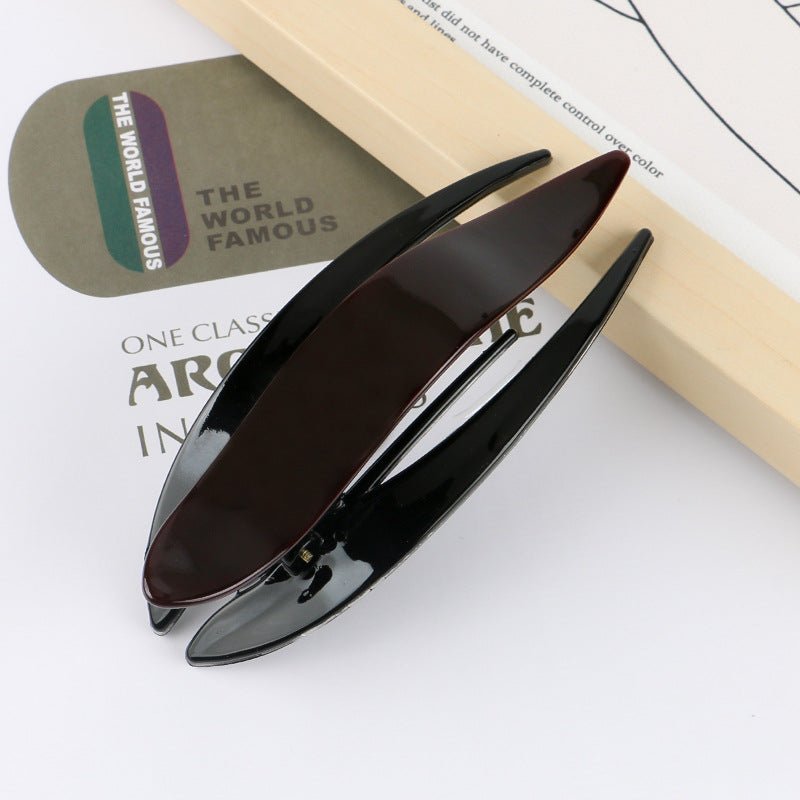 Lifestyle shot of various acetate hairpins on a natural background, showcasing their simple designs.
