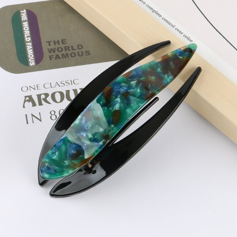 Detail close-up of teal acetate hairpin with unique pattern, showcasing its elegant design.