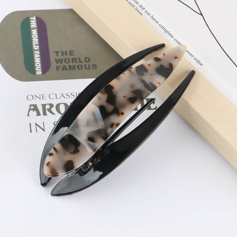Detail close-up of tortoise shell acetate hairpin, showcasing its stylish pattern and glossy finish.