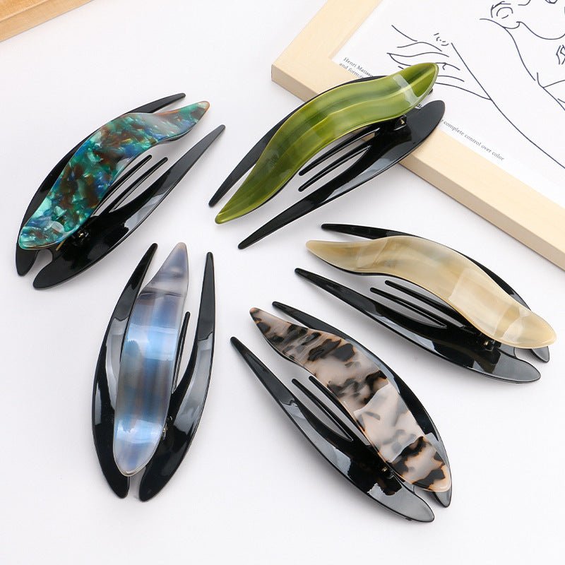 Lifestyle shot of acetate hairpin in tortoise shell, showcasing various designs in a natural setting.