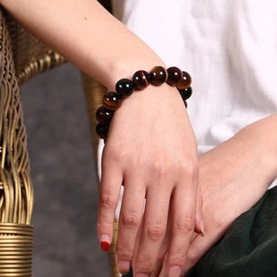 Detail close-up of the tiger eye bracelet with round beads in a simple design, featuring brown and gold colors.