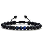 Detail close-up of black and gold couple bracelets with matte finish, showcasing elegant bead design.