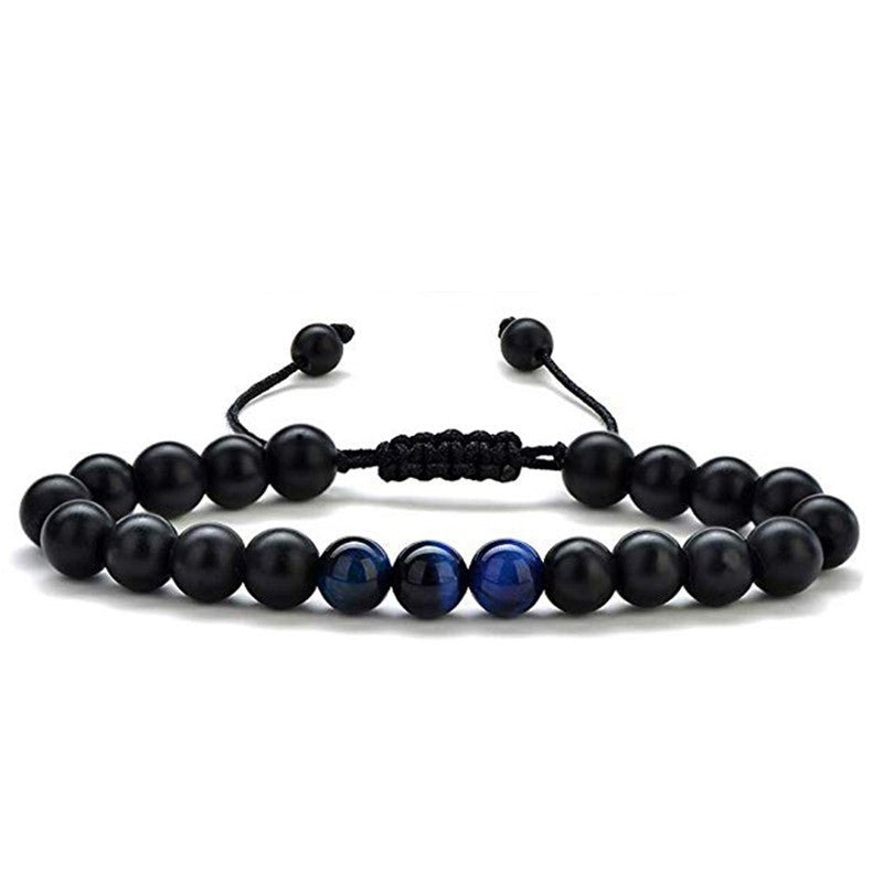 Detail close-up of black and gold couple bracelets with matte finish, showcasing elegant bead design.