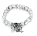 Side view of the vintage white turquoise bead bracelet highlighting its elastic band and tree charm.