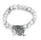 Side view of the vintage white turquoise bead bracelet highlighting its elastic band and tree charm.