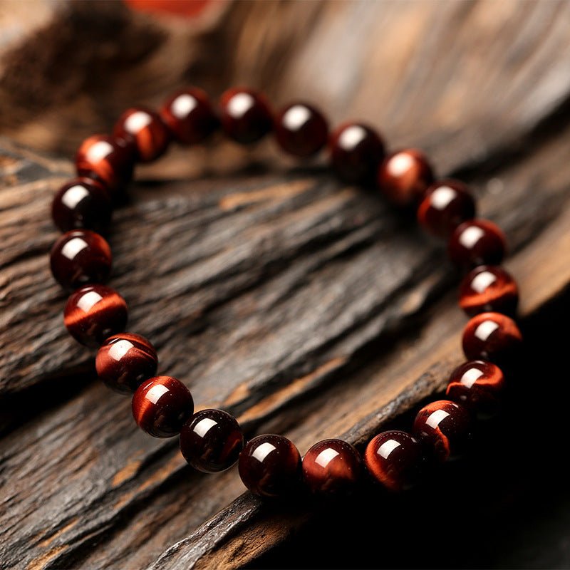 Detail close-up of vintage red tiger eye bracelet showcasing red and brown 8mm beads with smooth finish.