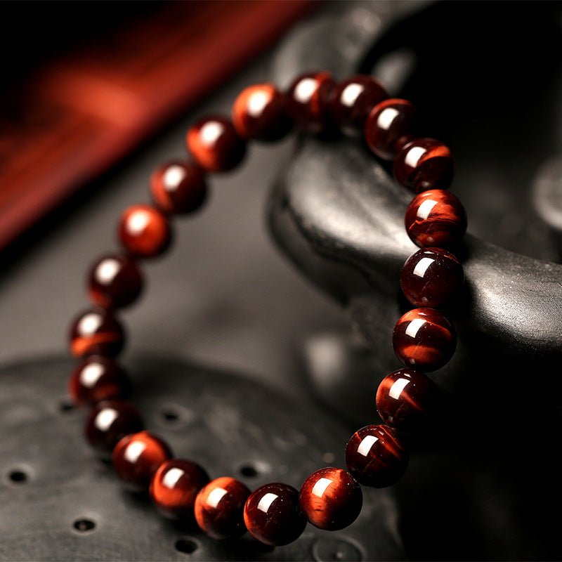 Detail close-up of vintage red tiger eye bracelet with unisex design on a natural background.