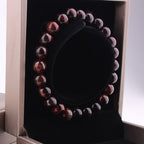 Vintage red tiger eye bracelet in packaging with display box, featuring round red and black 8mm beads.
