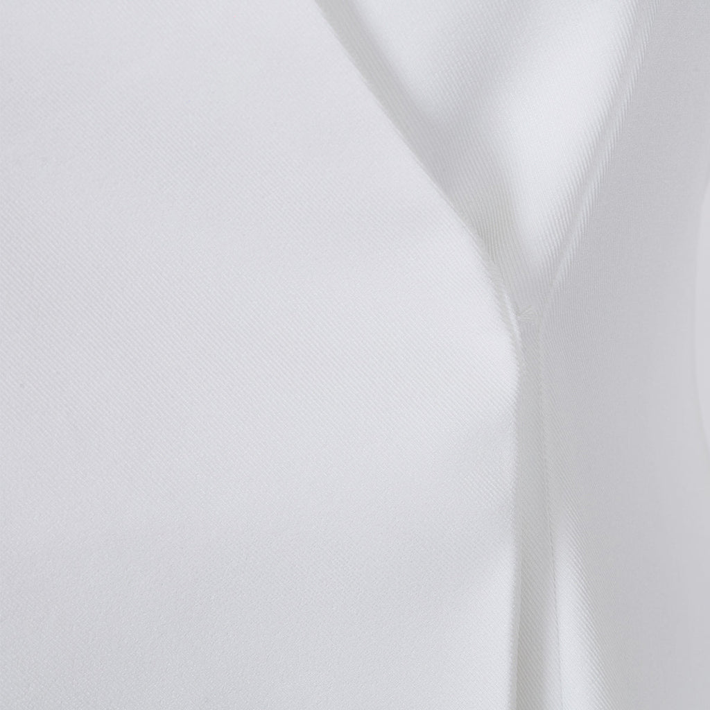 Close-up detail of the seam design on the white lapel blazer, highlighting its sophisticated craftsmanship.