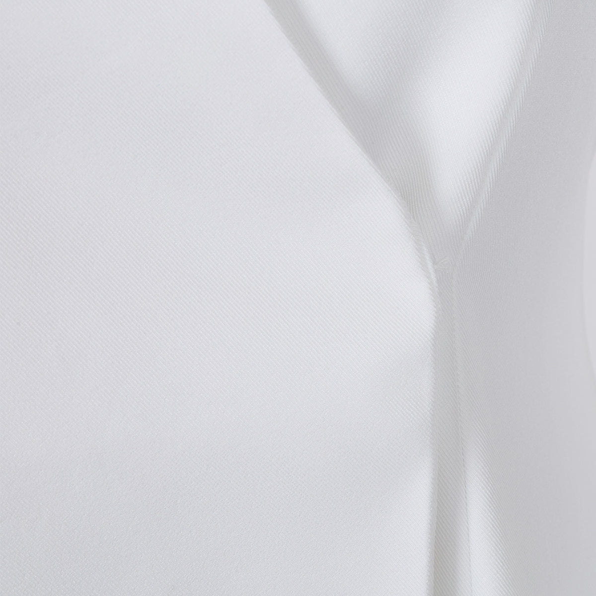 Close-up detail of the seam design on the white lapel blazer, highlighting its sophisticated craftsmanship.