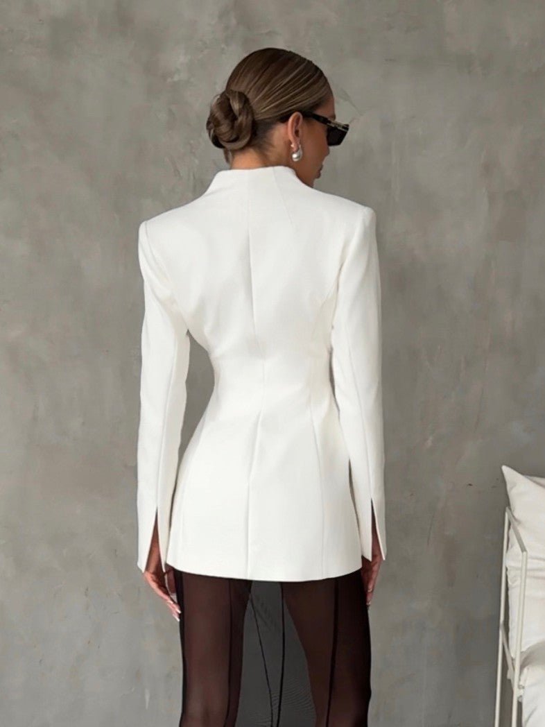 Back view of the white lapel blazer highlighting the tailored fit and lapel collar in a neutral setting.