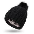 Front view of the black knitted beanie with faux fur pom pom, stylish winter accessory for a capsule wardrobe.