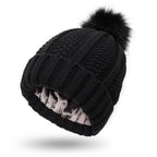 Front view of the black knitted beanie with faux fur pom pom, stylish winter accessory for a capsule wardrobe.