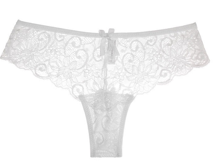 Front view of the white lace thong showcasing delicate lace detailing and a bow accent, elegant minimalist design.