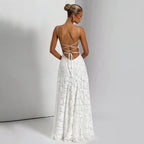 Back view of the white backless chiffon slip dress showcasing an open back and floral details in a studio.