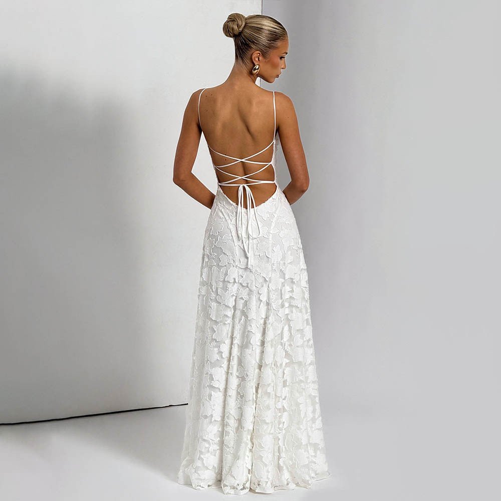 Back view of the white backless chiffon slip dress showcasing an open back and floral details in a studio.