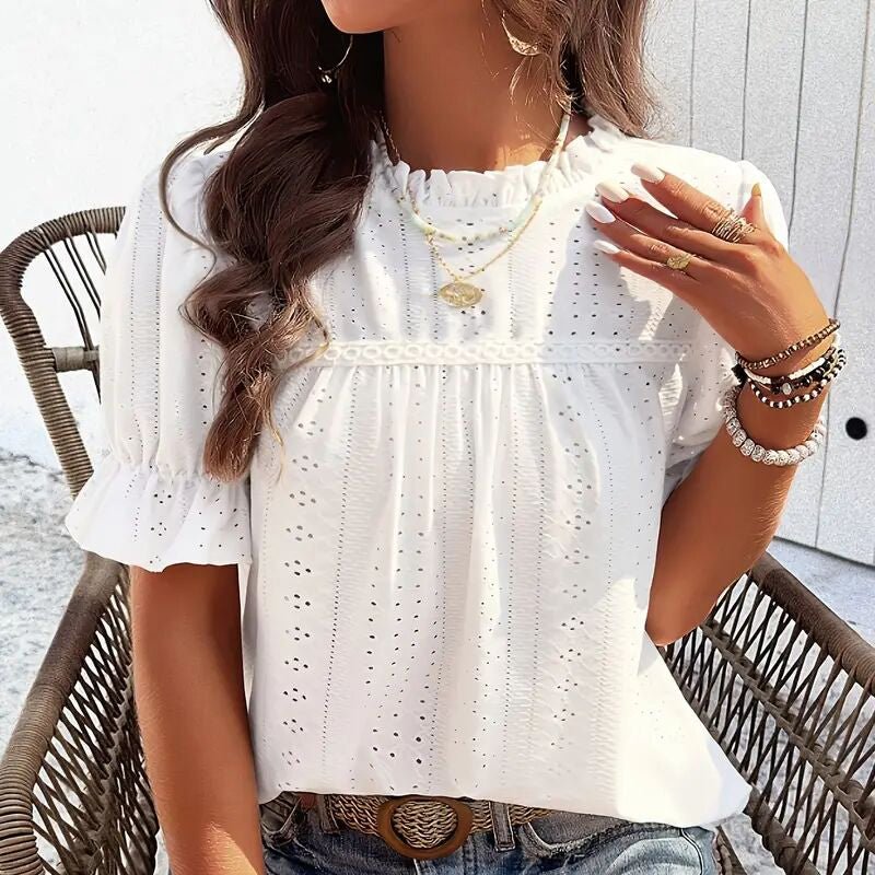 Lifestyle shot of a white ruffle blouse with short sleeves, elegant minimalist style for casual wear.