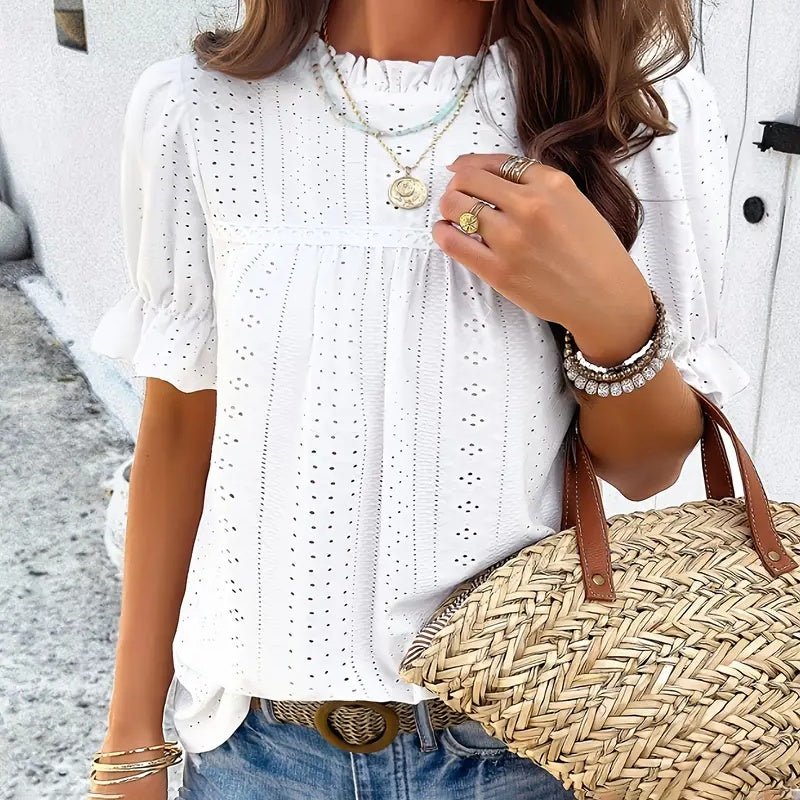 Lifestyle view of a white ruffle blouse with short sleeves, showcasing elegant details in a natural setting.