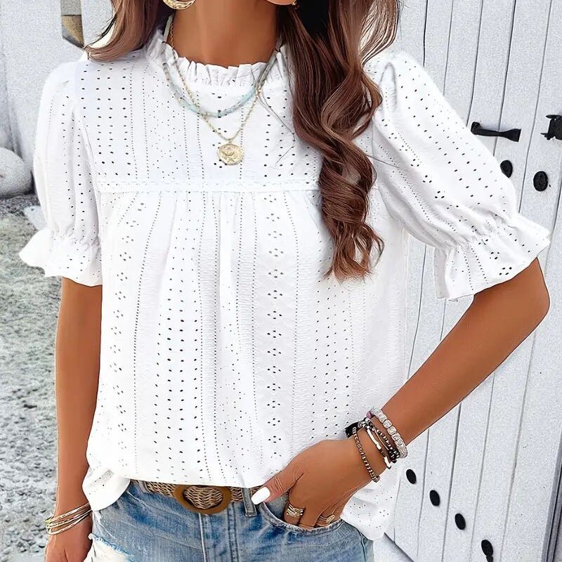 Lifestyle view of a white ruffle blouse with round neck and textured fabric, elegant addition to any minimalist outfit.
