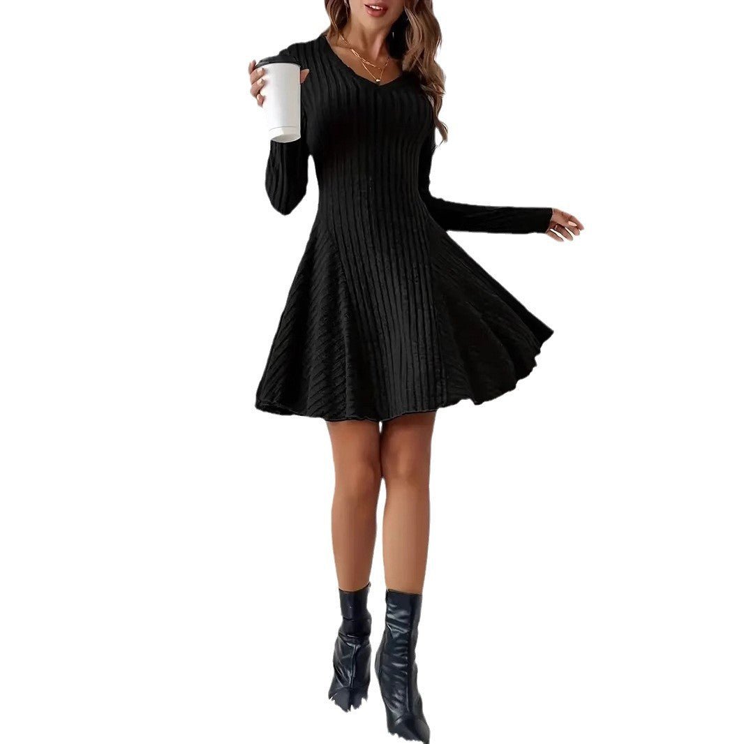 Front view of a black V-neck dress featuring long sleeves and flared skirt on a solid color background.
