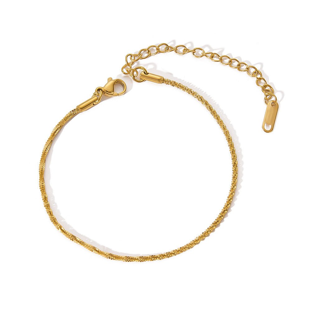 Close-up detail of a gold minimalist stainless steel bracelet with adjustable chain, highlighting its chic design.