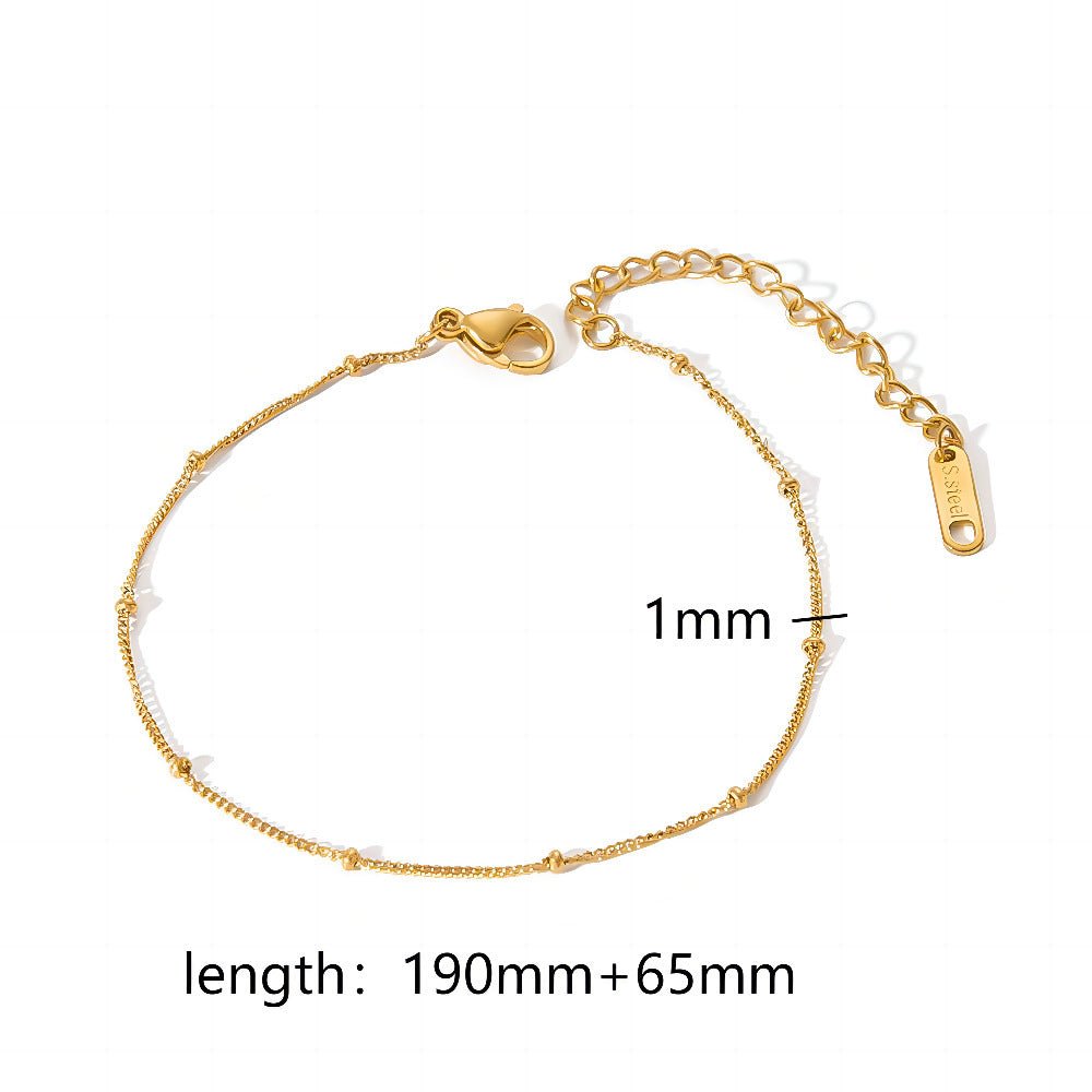 Close-up of a gold minimalist stainless steel bracelet with adjustable length, highlighting its delicate design.