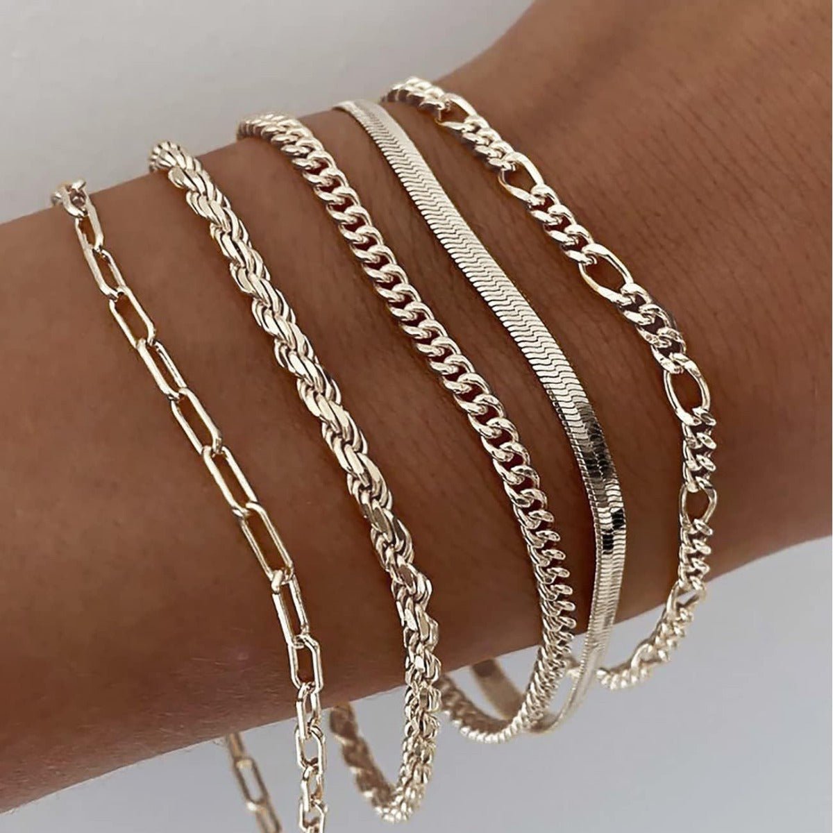 Lifestyle shot of a minimalist stainless steel bracelet set in gold and silver, showcasing layered styles.