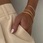 Detail shot of a gold minimalist stainless steel bracelet set, showcasing a variety of styles in an elegant arrangement.