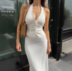 Lifestyle view of a white halter neck dress featuring a deep V-neck and midi length, elegant fashion @Black#White