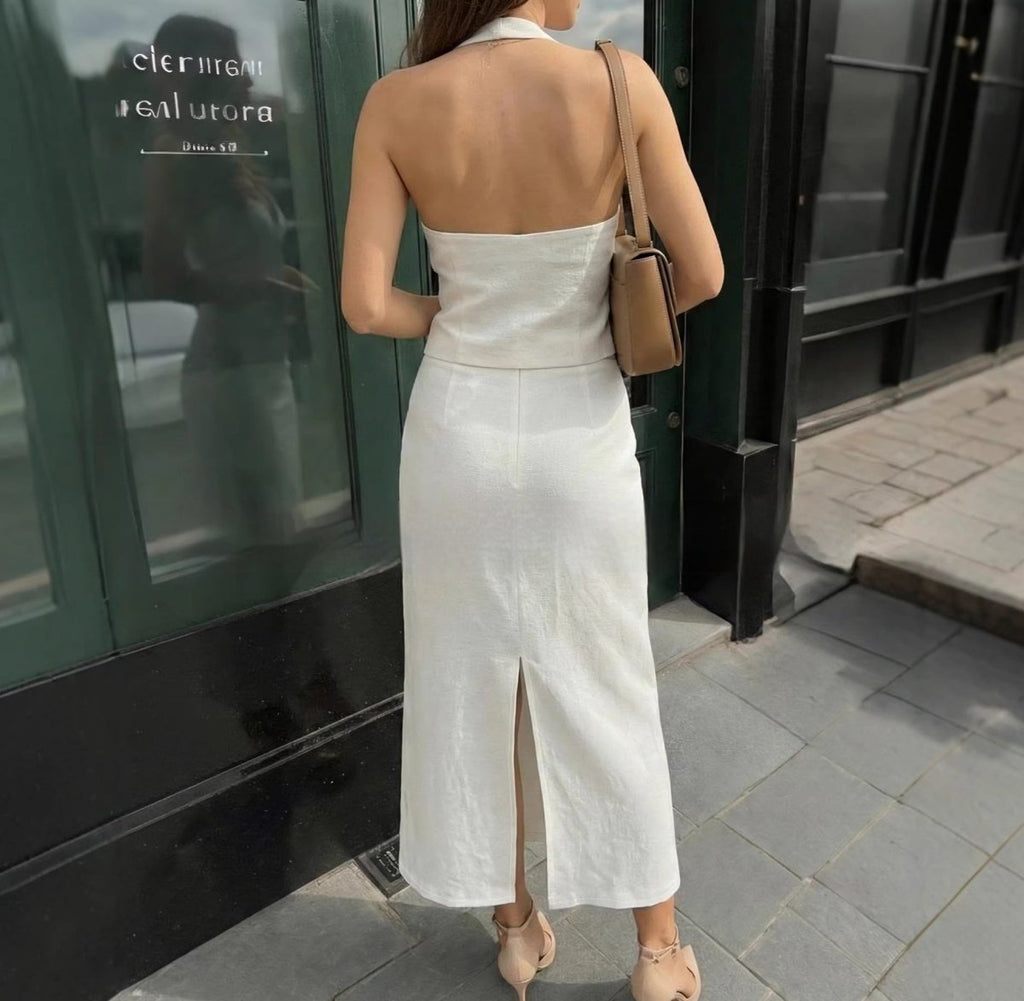 Lifestyle view of a white halter neck dress showcasing the open back, elegant fashion piece @Black#White