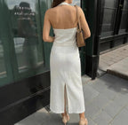 Lifestyle view of a white halter neck dress showcasing the open back, elegant fashion piece @Black#White