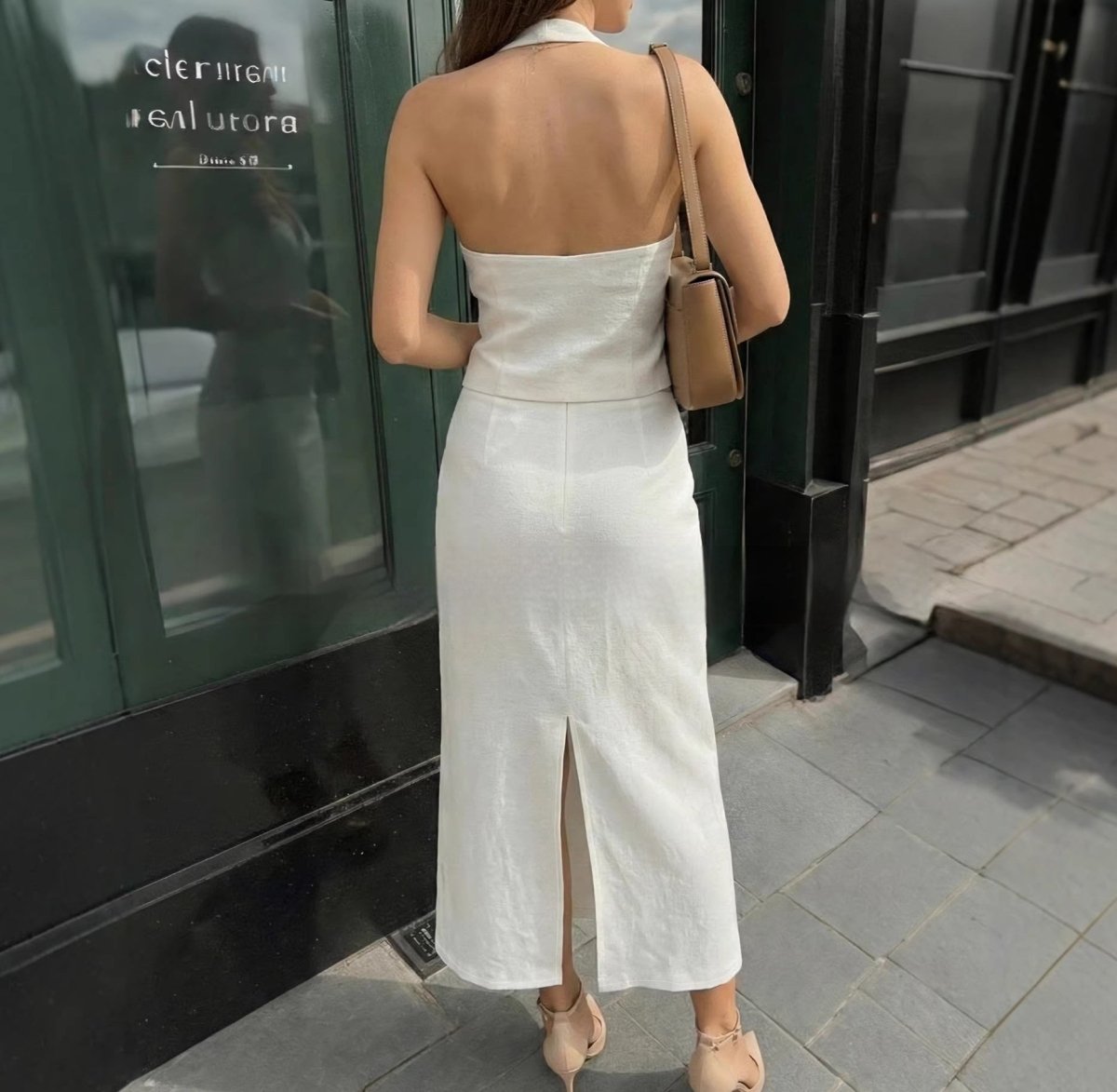 Lifestyle view of a white halter neck dress showcasing the open back, elegant fashion piece @Black#White