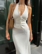 Lifestyle shot of a white halter neck dress featuring a slit detail, sophisticated minimalist look @Black#White