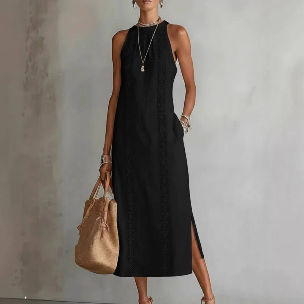 Sophisticated black halter neck dress with lace patchwork and side slit in lifestyle shot.