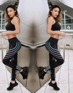 Lifestyle image of a woman wearing black high-waist leggings with glow effect, set in a natural background.