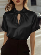 Lifestyle shot of a black satin short-sleeve top with keyhole neckline, chic and elegant design
