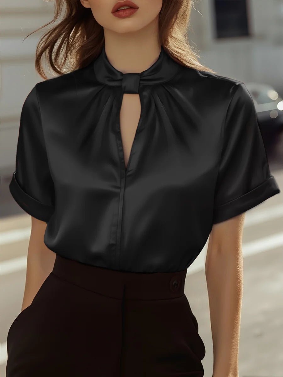 Lifestyle shot of a black satin short-sleeve top with keyhole neckline, chic and elegant design