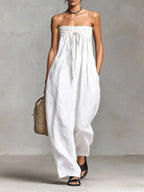 Elegant white strapless jumpsuit showcasing ruched details in a lifestyle setting.