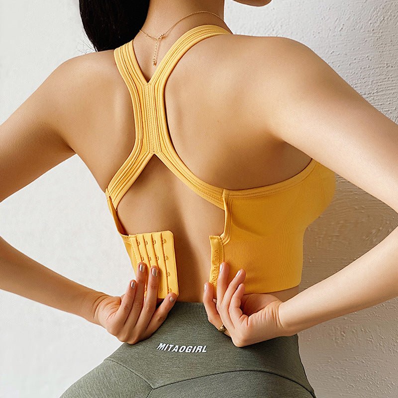 Back view of the yellow sports bra with hook closure, showcasing its open back and comfortable fit.