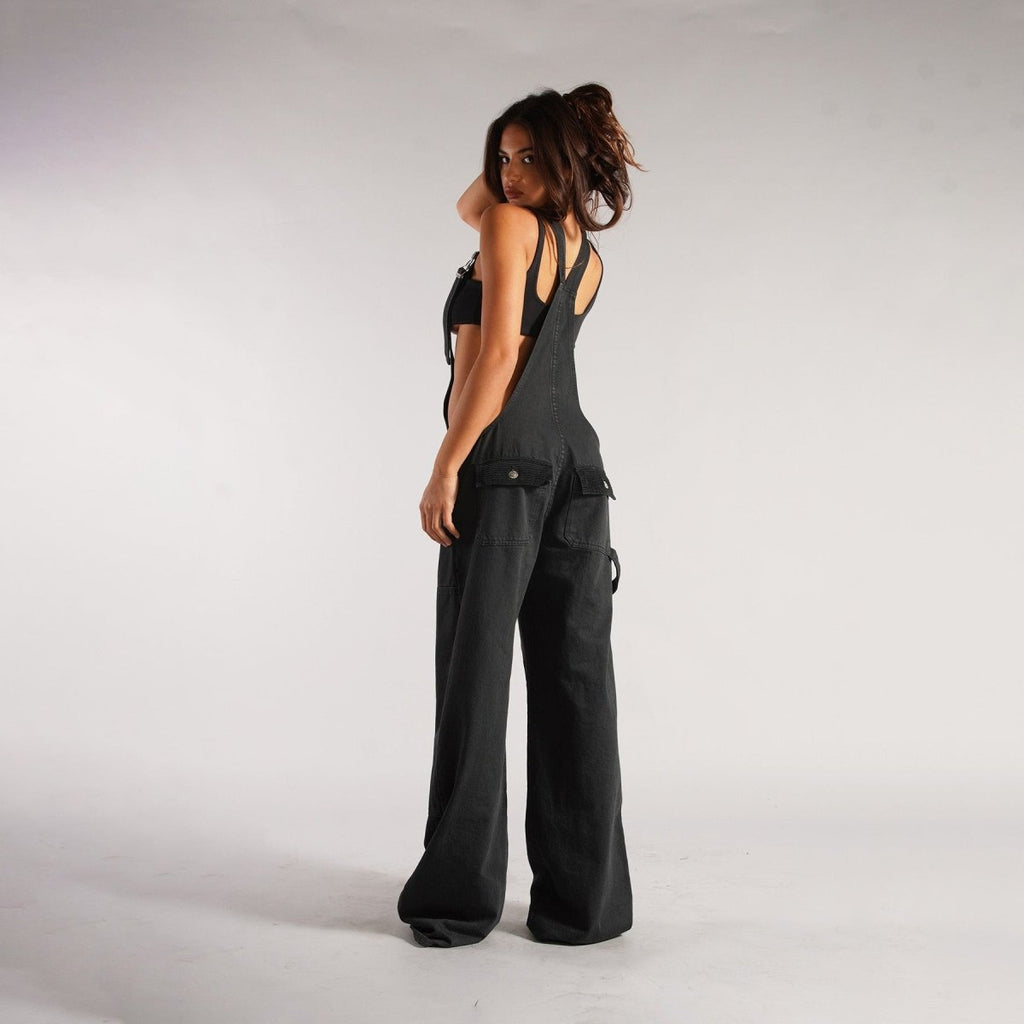 Back view of black loose denim overalls emphasizing the high waist design and wide leg cut, a trendy addition to any wardr…
